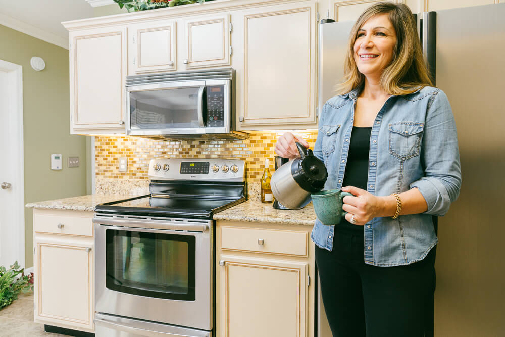 N-Hance refinished kitchen with a woman pouring coffee
