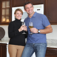 couple enjoying the new year in front of walnut cabinets in kitchen