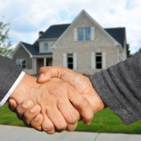 shaking hands in front of a house
