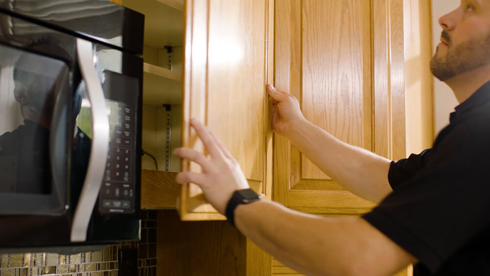 N-Hance franchise employee removes kitchen cabinet door